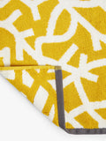 Mini Moderns cotton bath mat with forest graphic print in mustard, imported from the UK