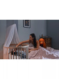 Stokke mini oval crib with natural finish, adjustable height, and wheels (British brand)