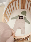 Stokke mini oval crib with natural finish, adjustable height, and wheels (British brand)