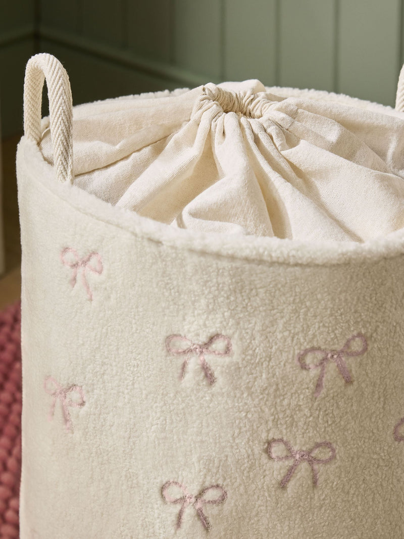 Cream bow laundry hamper with embroidered bows, imported from the UK