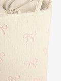 Cream bow laundry hamper with embroidered bows, imported from the UK