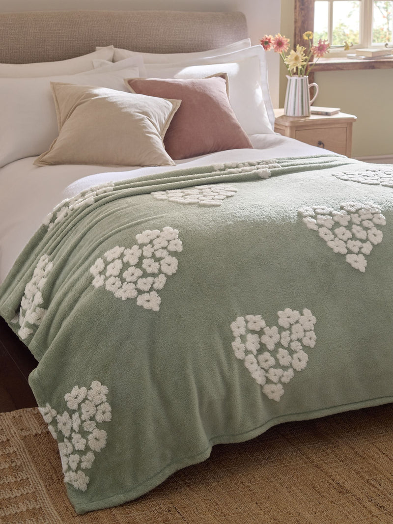 Sage green fleece throw with floral heart motifs, UK version