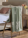 Sage green fleece throw with floral heart motifs, UK version