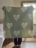 Sage green fleece throw with floral heart motifs, UK version