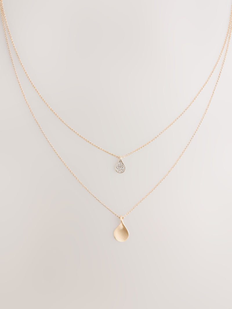 Gold tone layered necklace with sparkling and plain pendants, imported from the UK