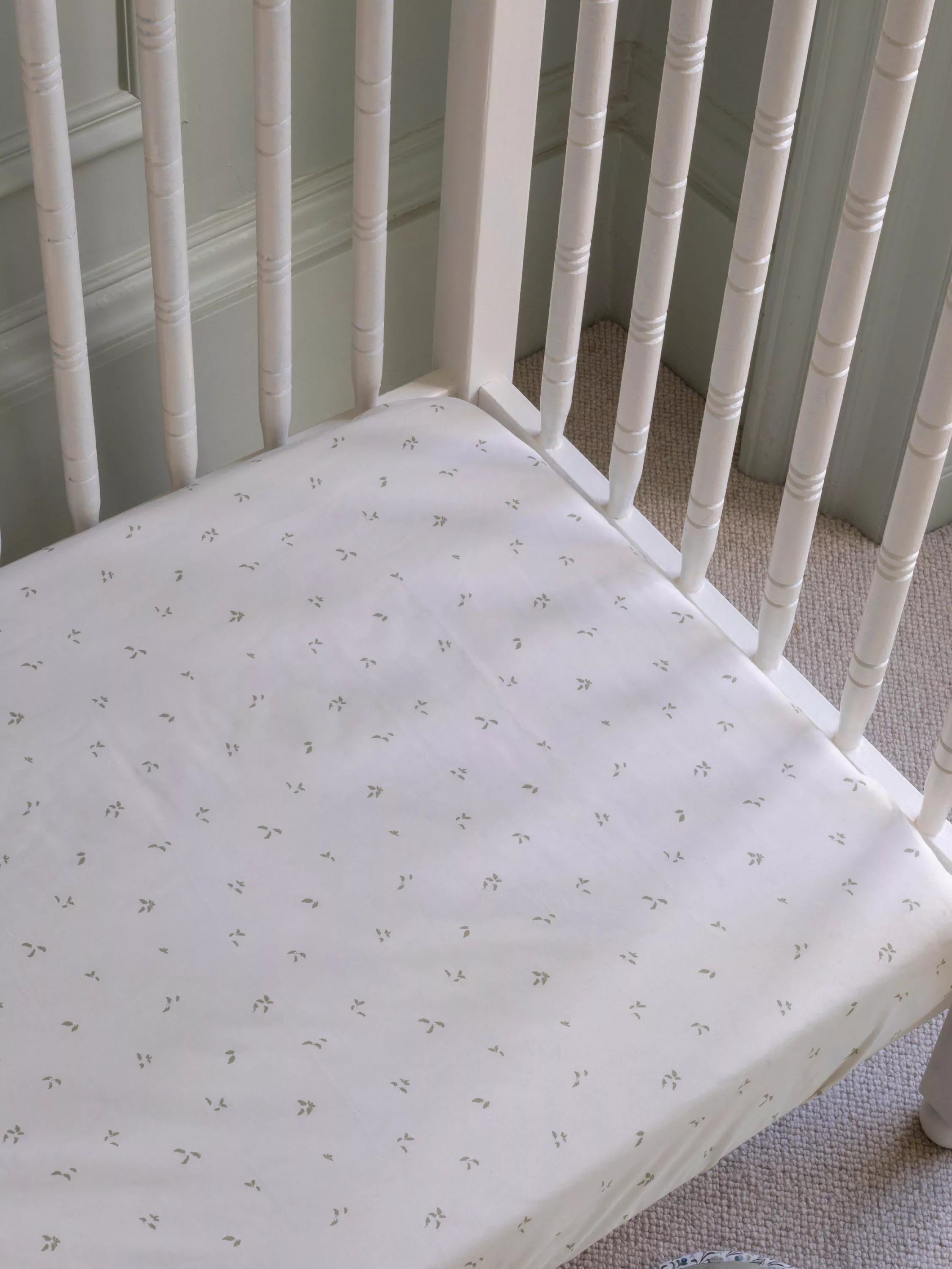 Avery Row cotbed fitted sheet nettle scatter pattern imported from the UK