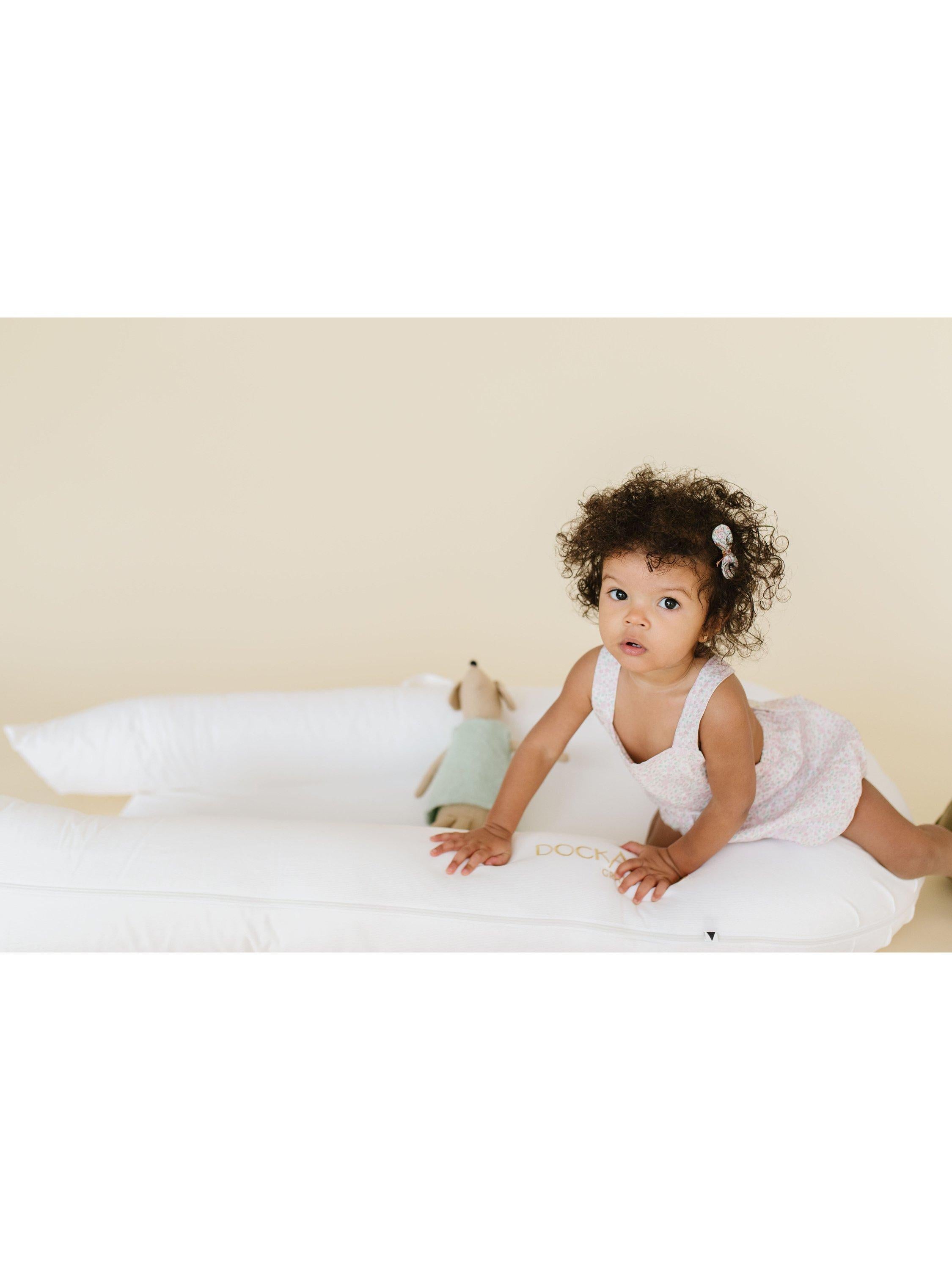 DockATot Grand Toddler Dock white toddler lounger, imported from the UK