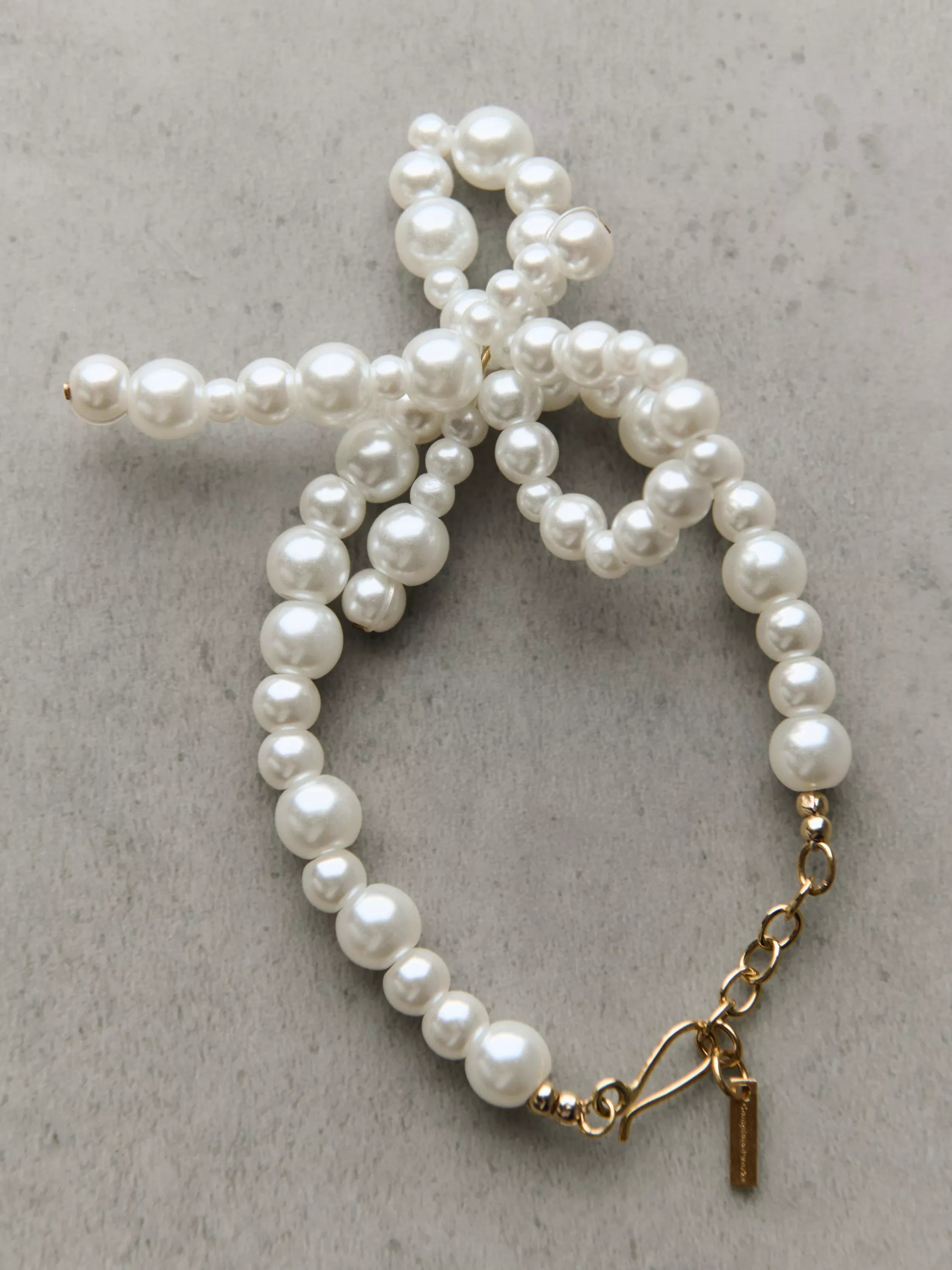 Completedworks glass pearl bow bracelet gold, UK version