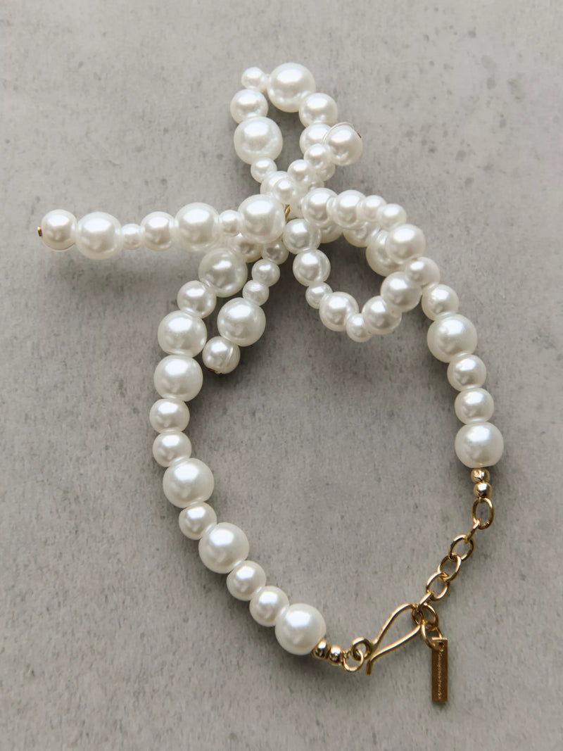 Completedworks glass pearl bow bracelet gold, UK version