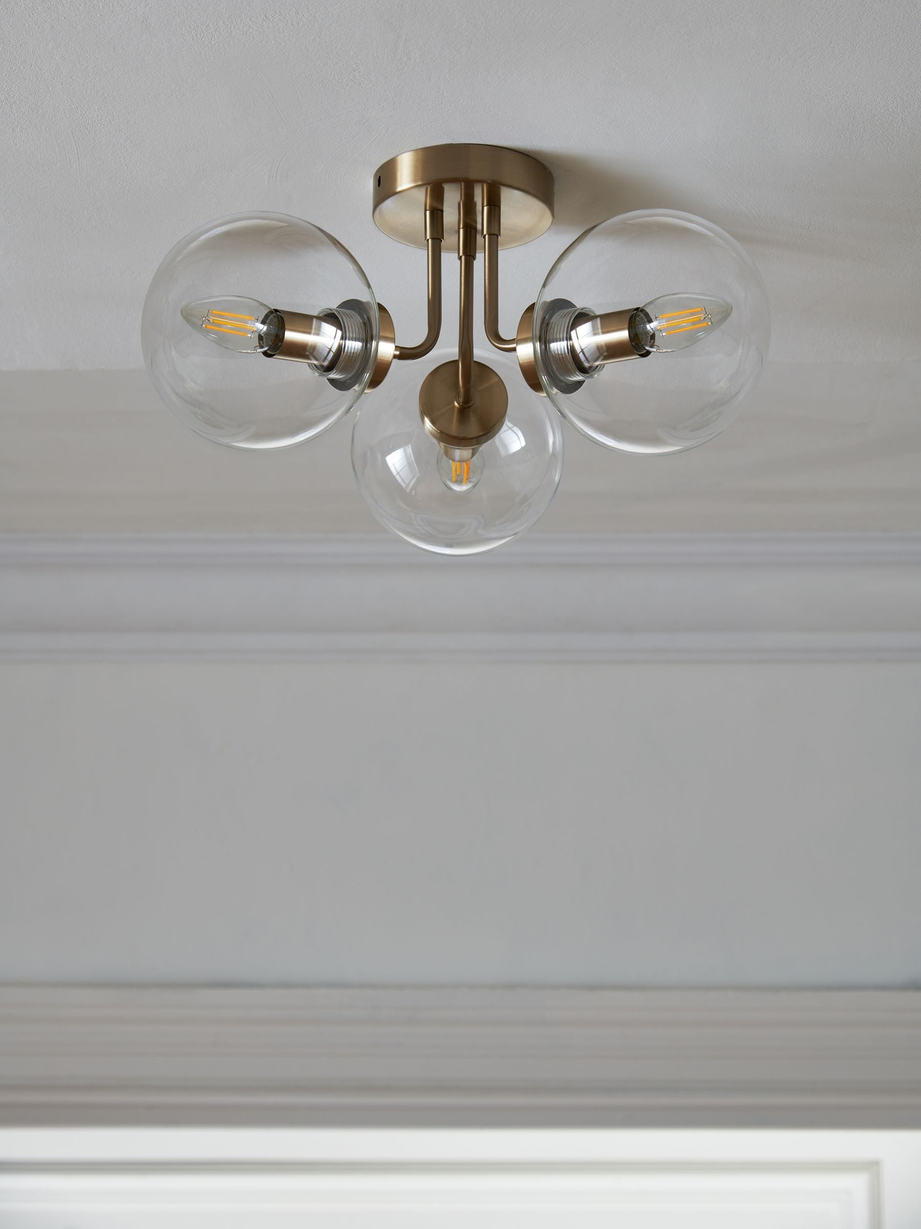 Brass Jackson flush ceiling light with three clear glass shades, UK version