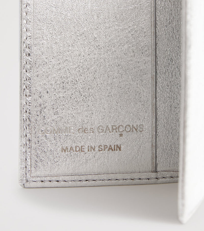 Comme des Garçons vertical bifold card holder with gold accents, imported from the UK