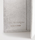 Comme des Garçons vertical bifold card holder with gold accents, imported from the UK