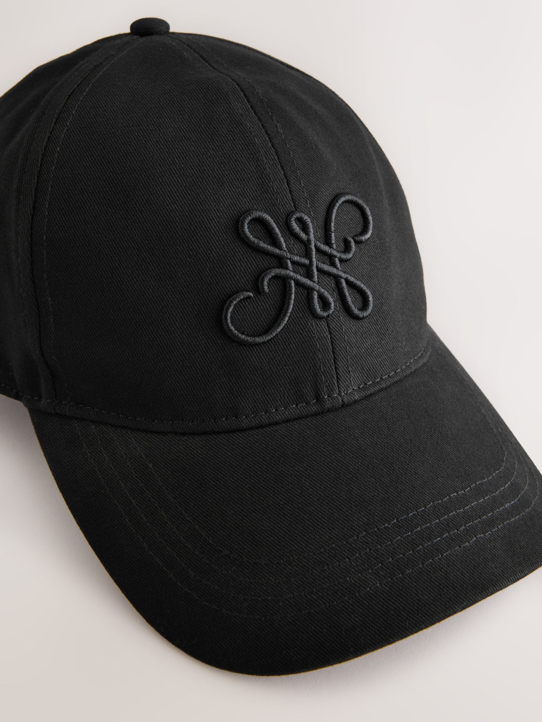 Black high build embroidery cap with curved brim (British brand)