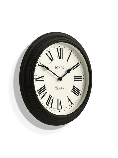 الساعة التالية ساعة حائط كلاسيكية بشريط أسود من Jones Clocks بأرقام رومانية، 40 سم - اشترِ عبر الإنترنت من McGrocer