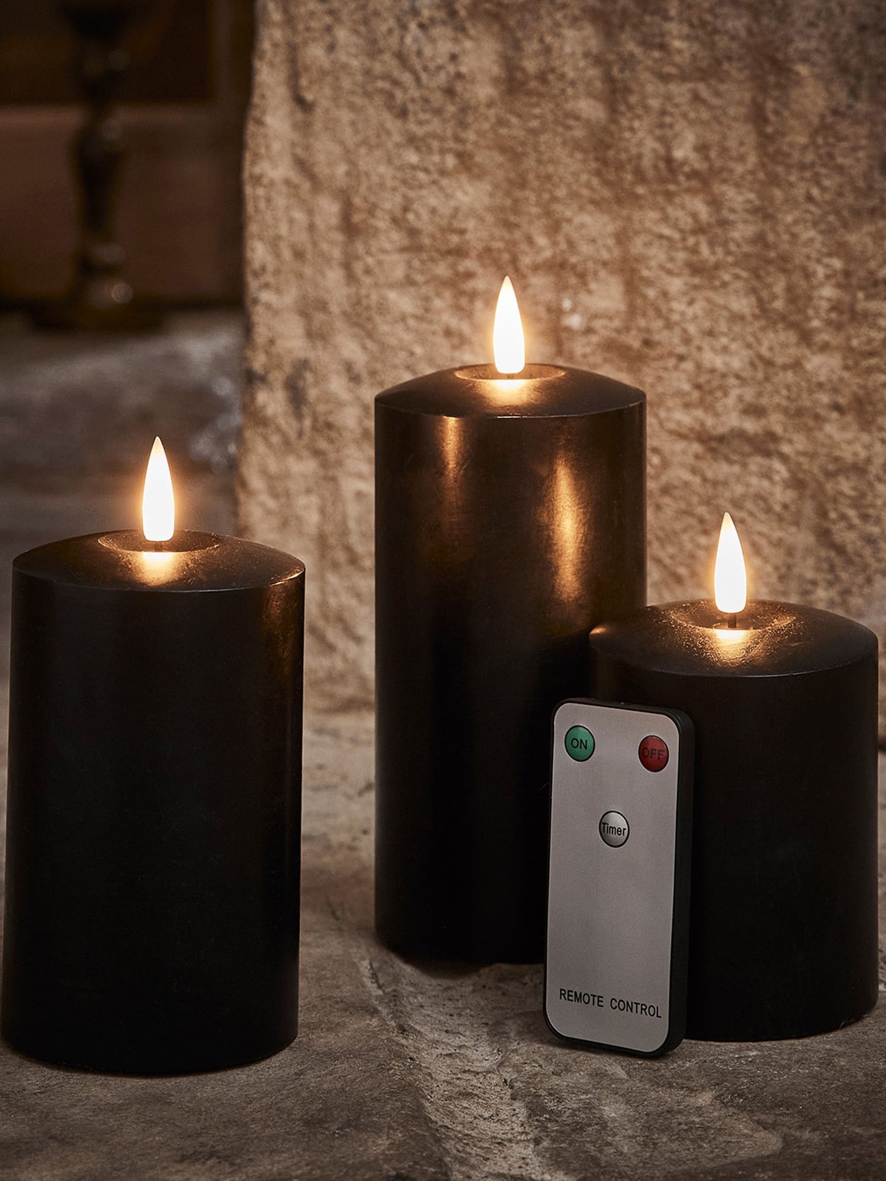 Lights4fun black TruGlow LED pillar candle trio with 15cm, 12.5cm, and 10cm heights, UK version
