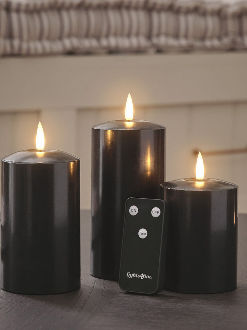 Lights4fun black TruGlow LED pillar candle trio with 15cm, 12.5cm, and 10cm heights, UK version