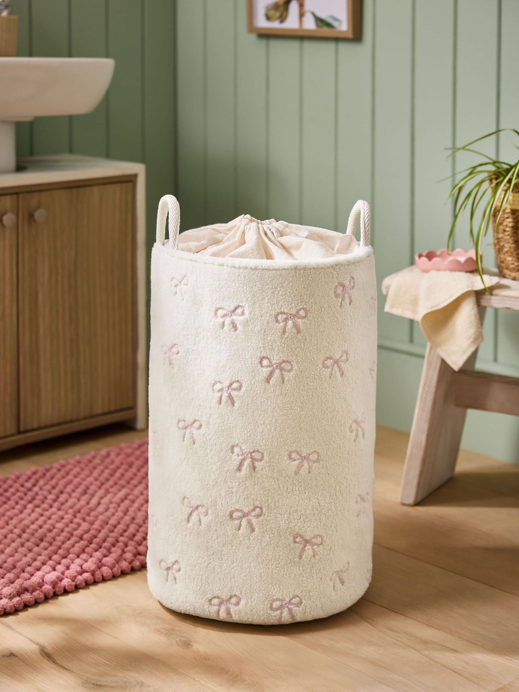 Cream bow laundry hamper with embroidered bows, imported from the UK