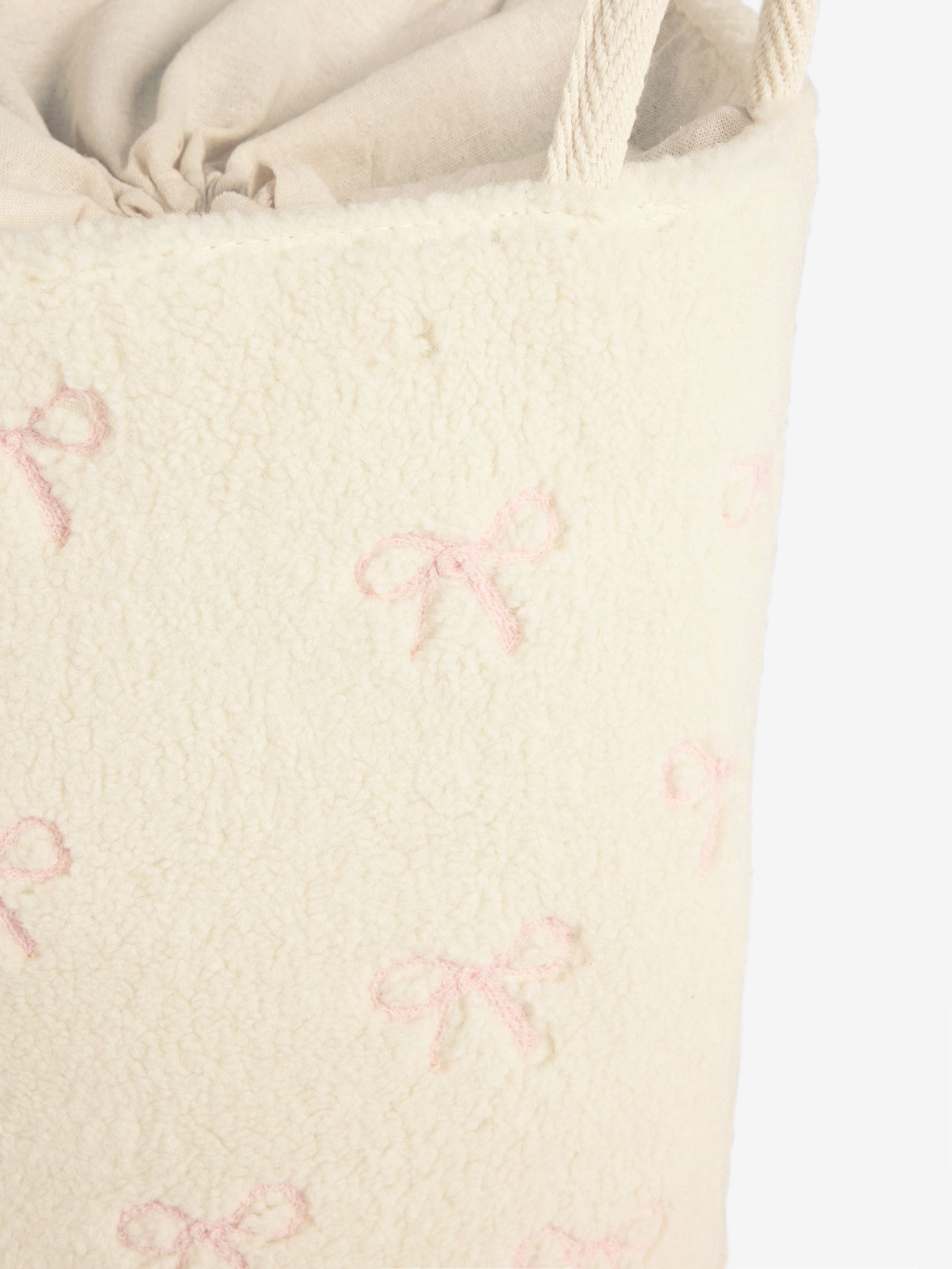 Cream bow laundry hamper with embroidered bows, imported from the UK