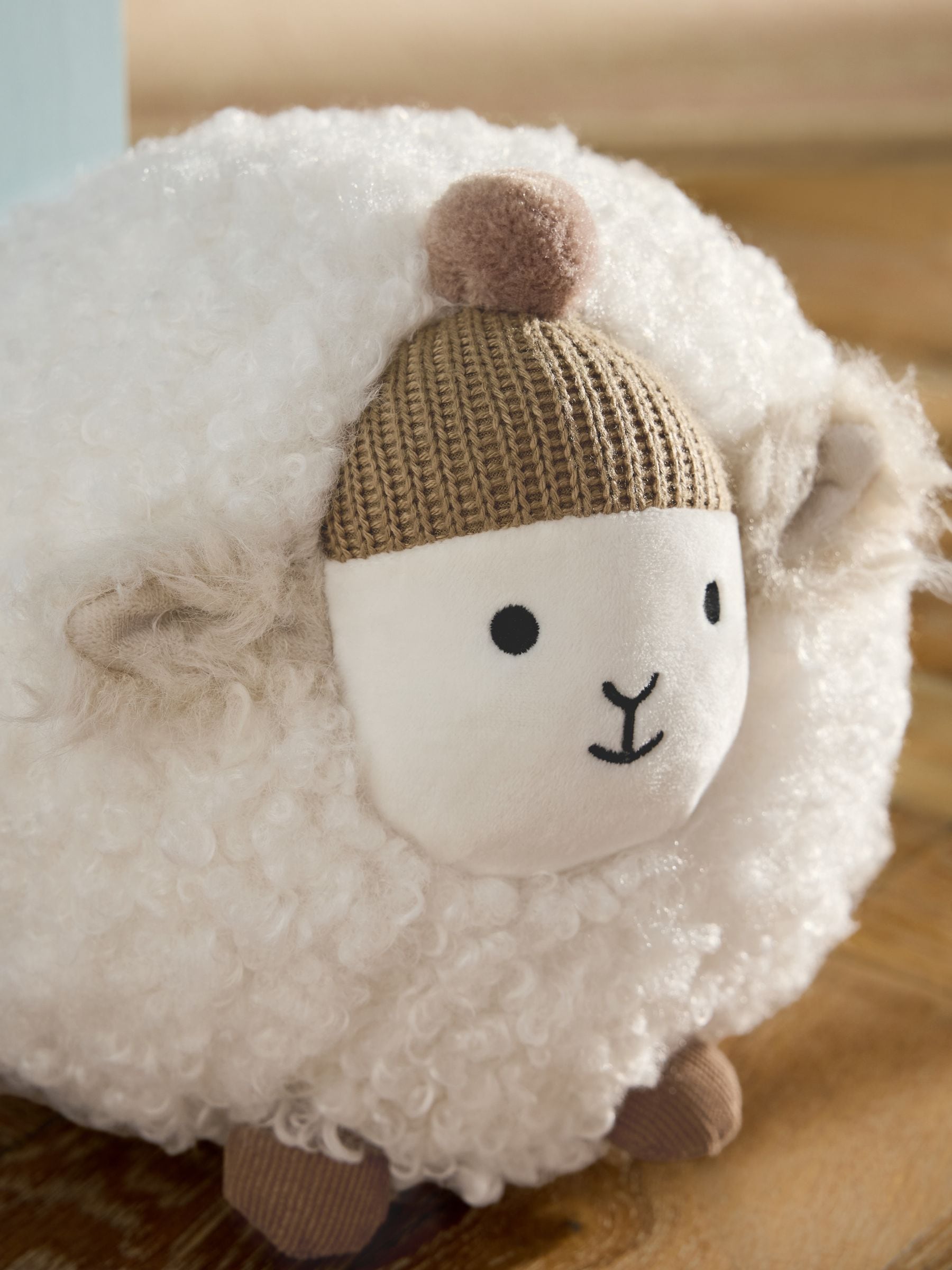 Natural sheep doorstop with knitted bobble hat and rustic tones - British product