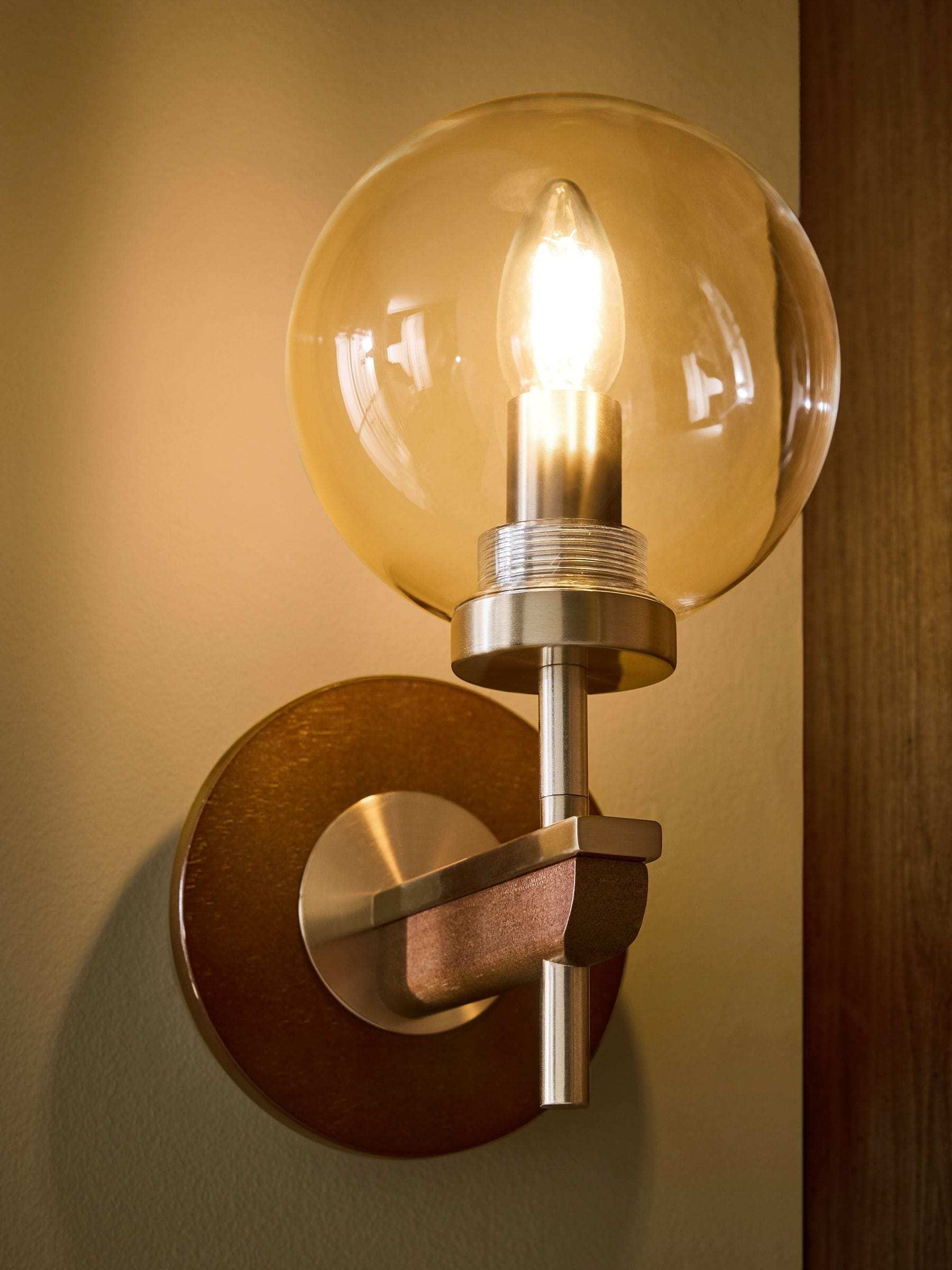 Archer wall light in dark natural wood with brass accents, British product