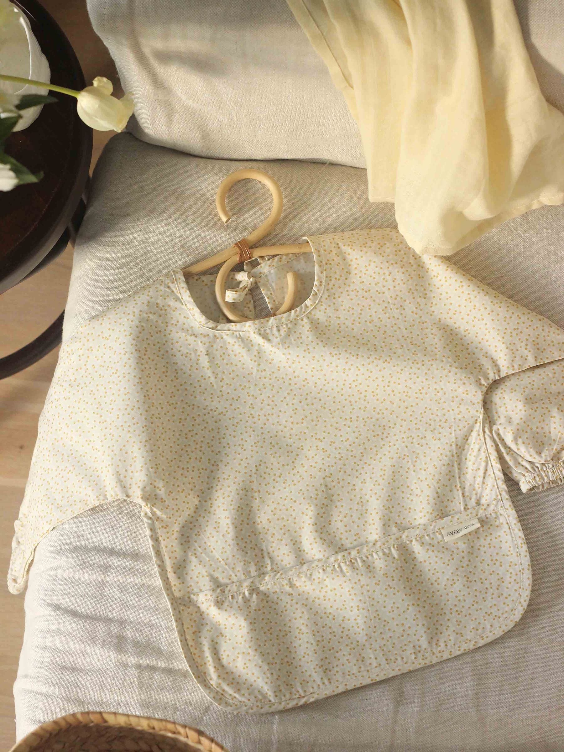 Avery Row sleeved bib in Daisy Meadow pattern (British brand)