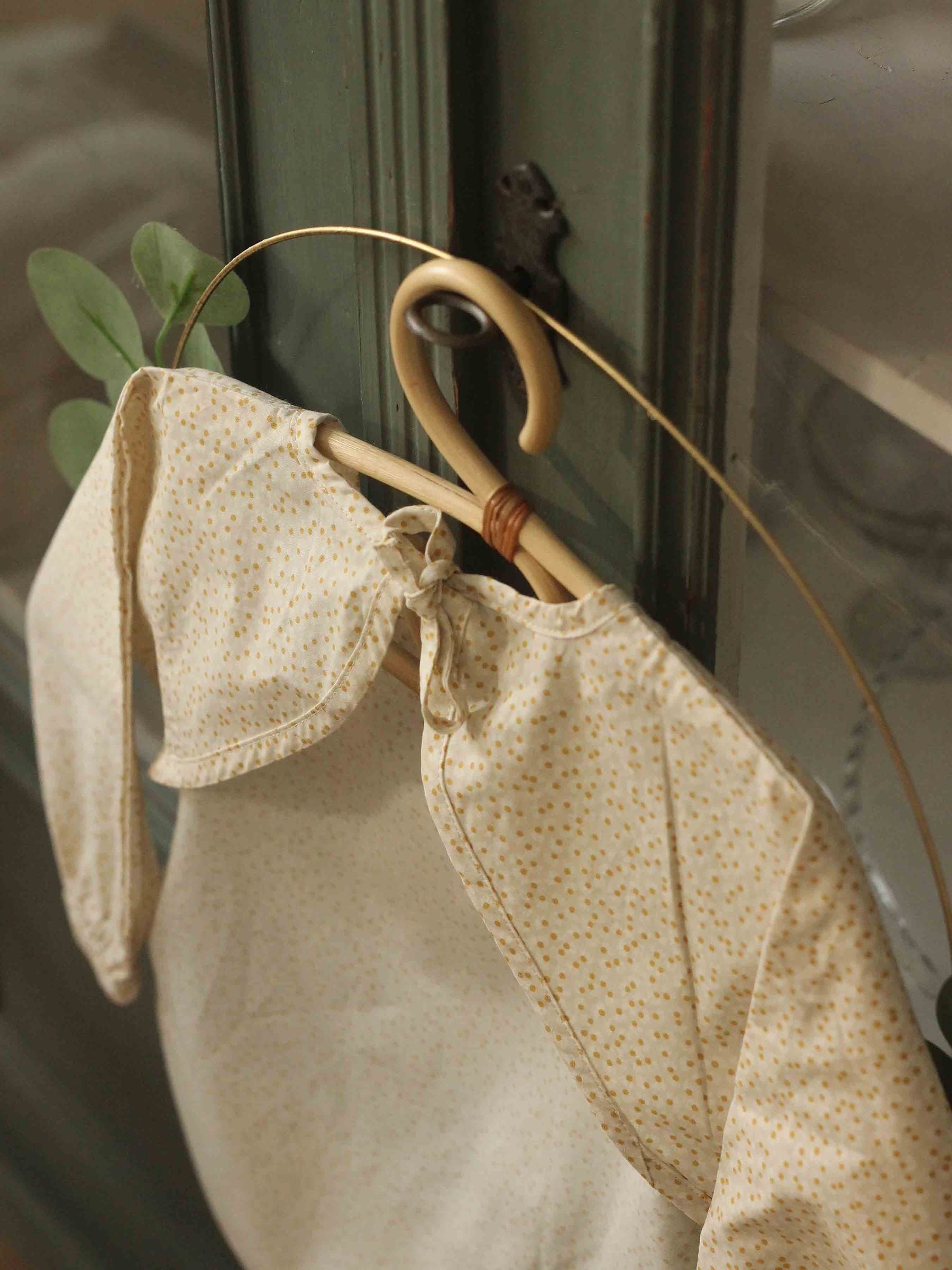 Avery Row sleeved bib in Daisy Meadow pattern (British brand)