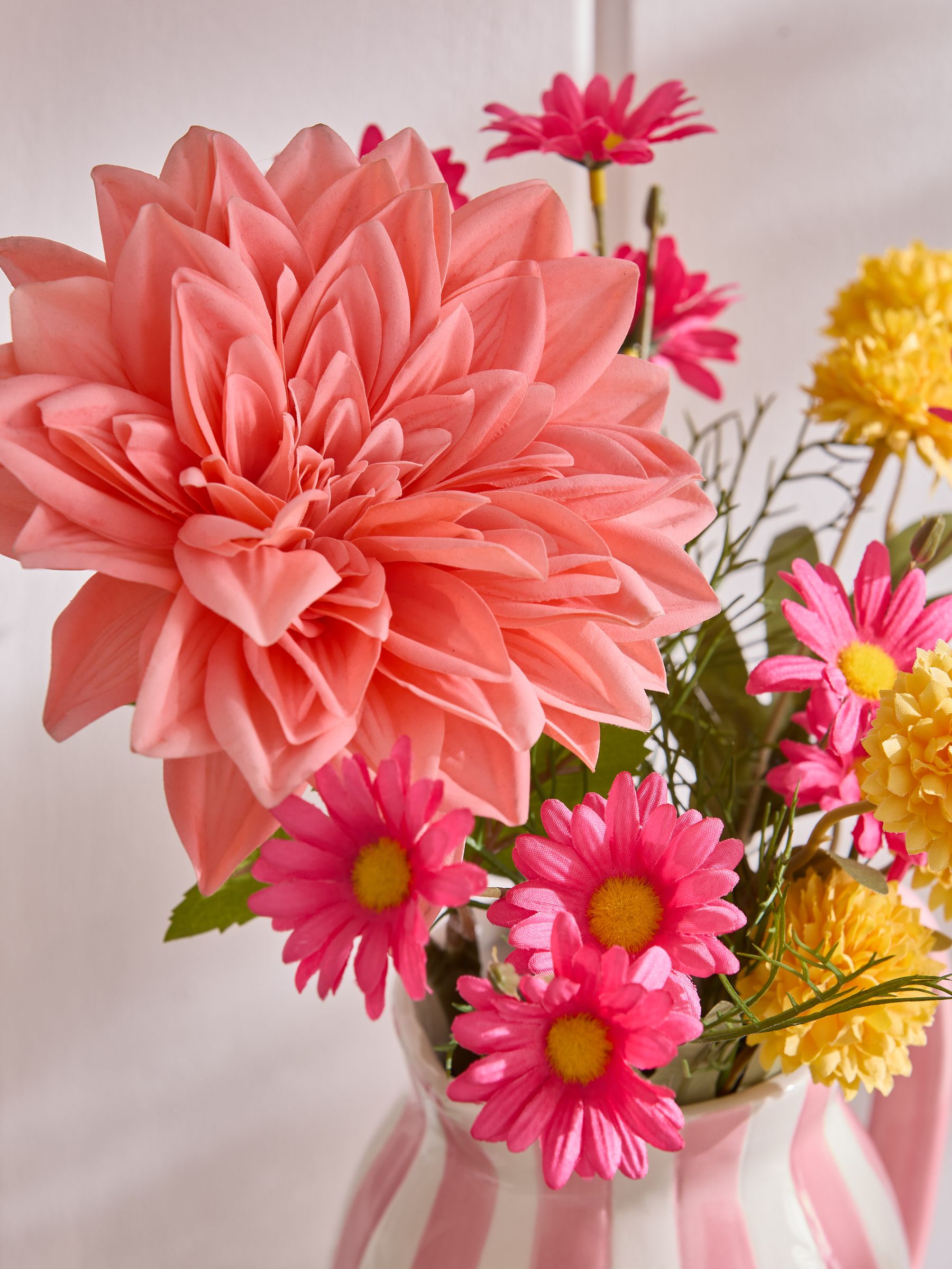 Lucy Tiffney pink artificial dahlia arrangement in striped jug vase, UK version