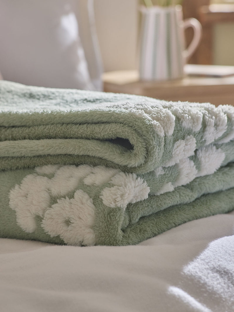 Sage green fleece throw with floral heart motifs, UK version
