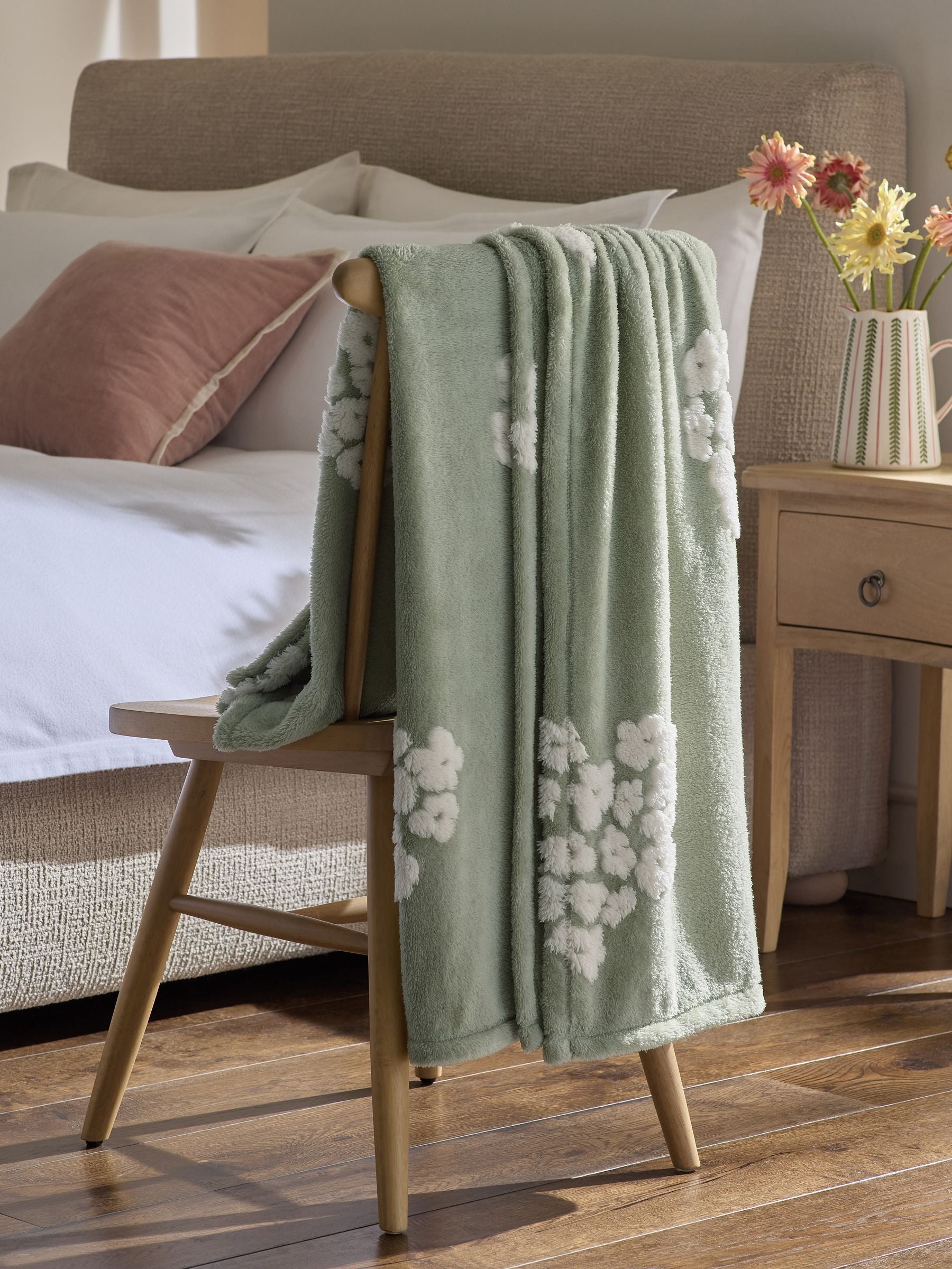 Sage green fleece throw with floral heart motifs, UK version
