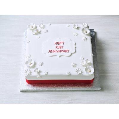 Red celebration cake with white icing and red ribbon - British product