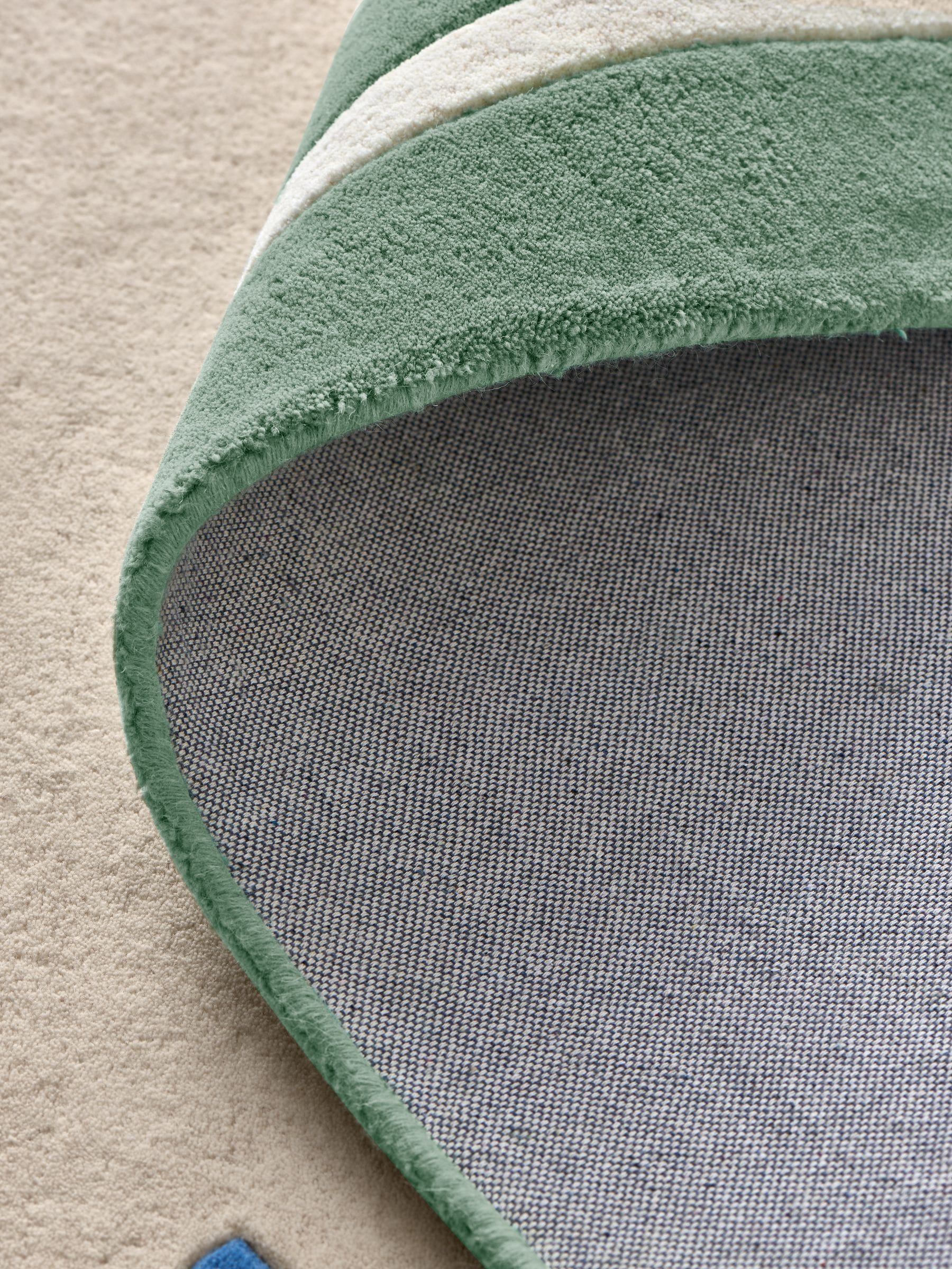 Joules sage green wool rug with scalloped border, imported from the UK