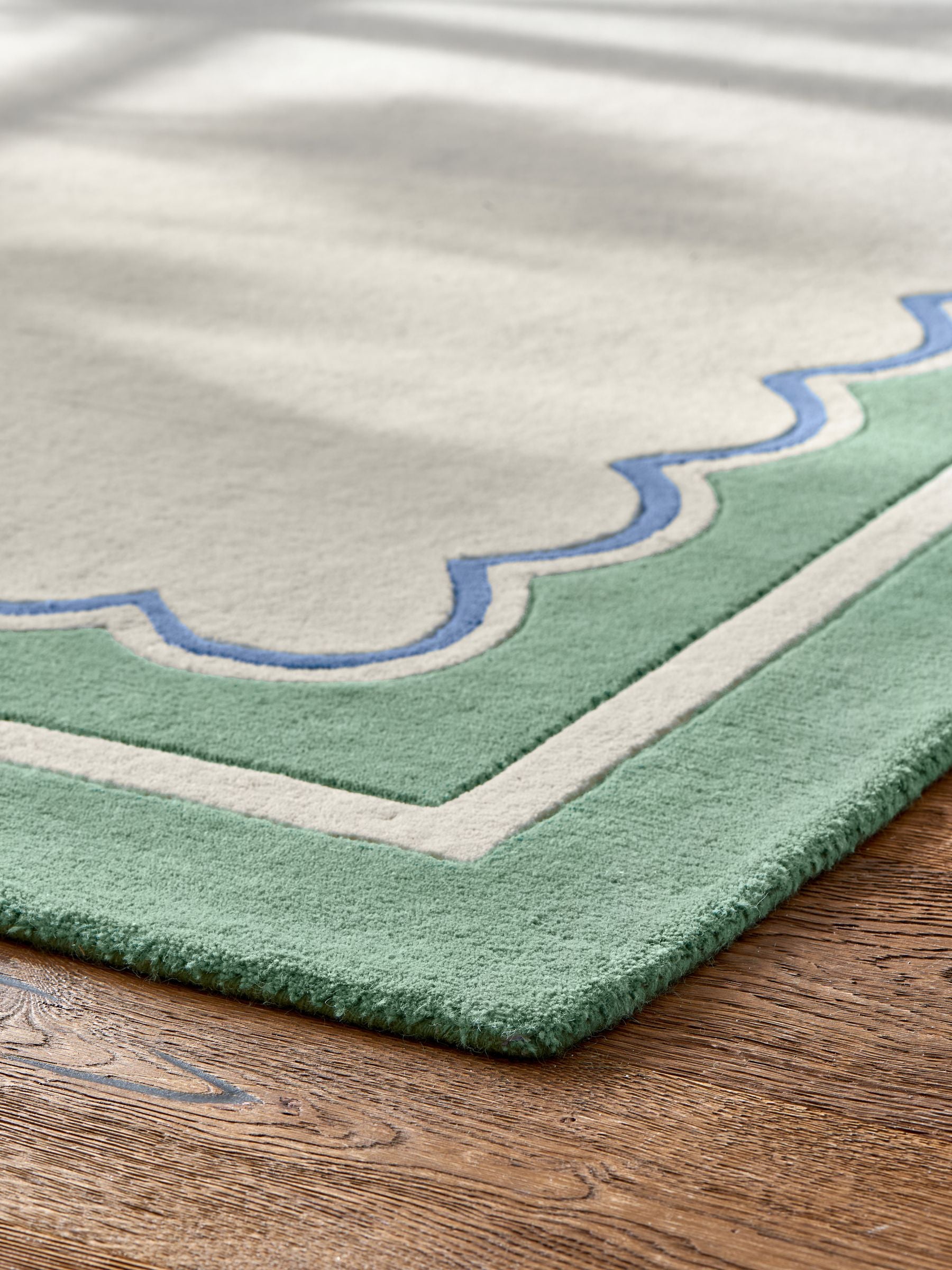 Joules sage green wool rug with scalloped border, imported from the UK