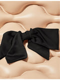 Kitsch bow-shaped fabric hair clip with oversized bow, imported from the UK