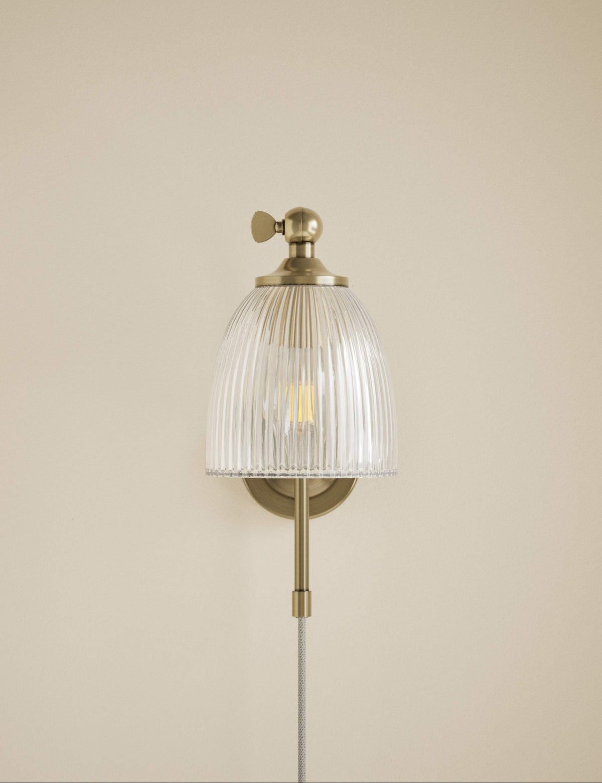 Ribbed plug in wall light with antique brass finish, imported from the UK