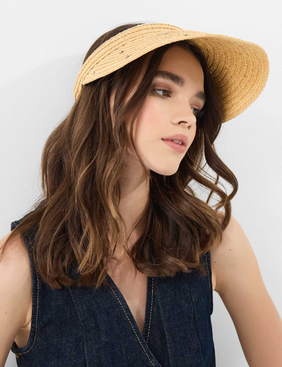 Accessorize straw visor with sparkly embellishments, imported from the UK