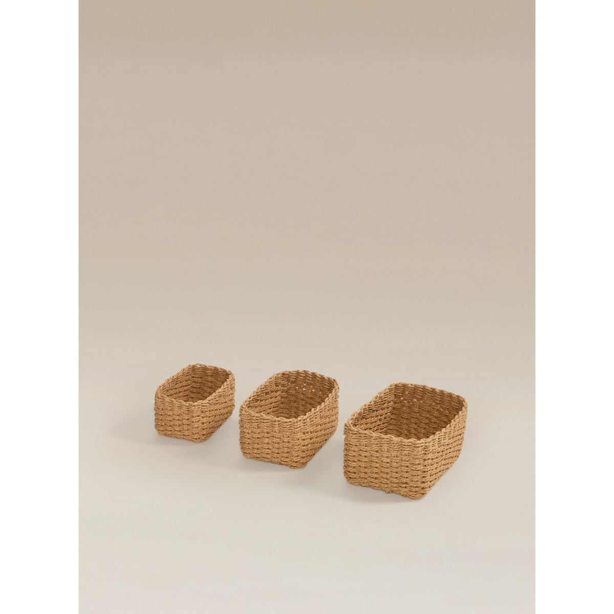 Three natural brown woven baskets, imported from the UK