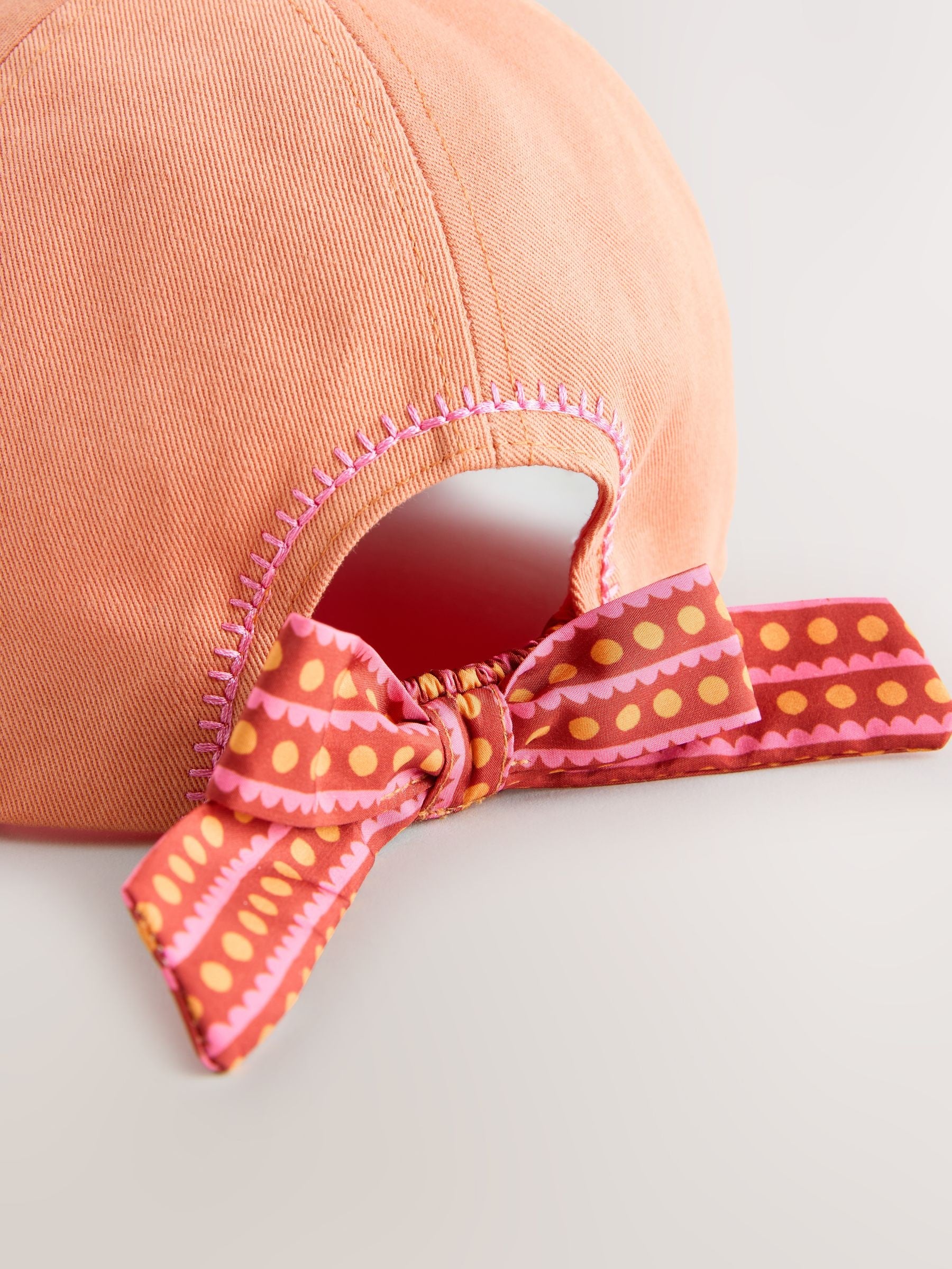 Children's orange baseball cap with scarf bow back (British brand)