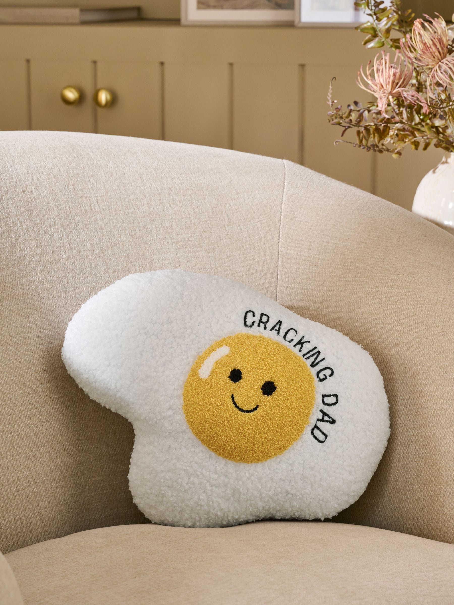 Father's Day cracking egg cushion in ochre yellow, imported from the UK
