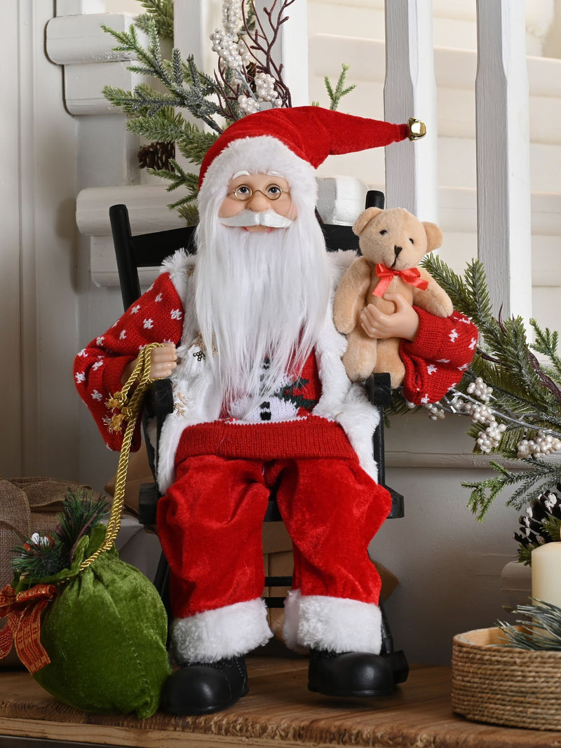 Santa figurine sitting in wooden rocking chair with snowman jumper (British brand)