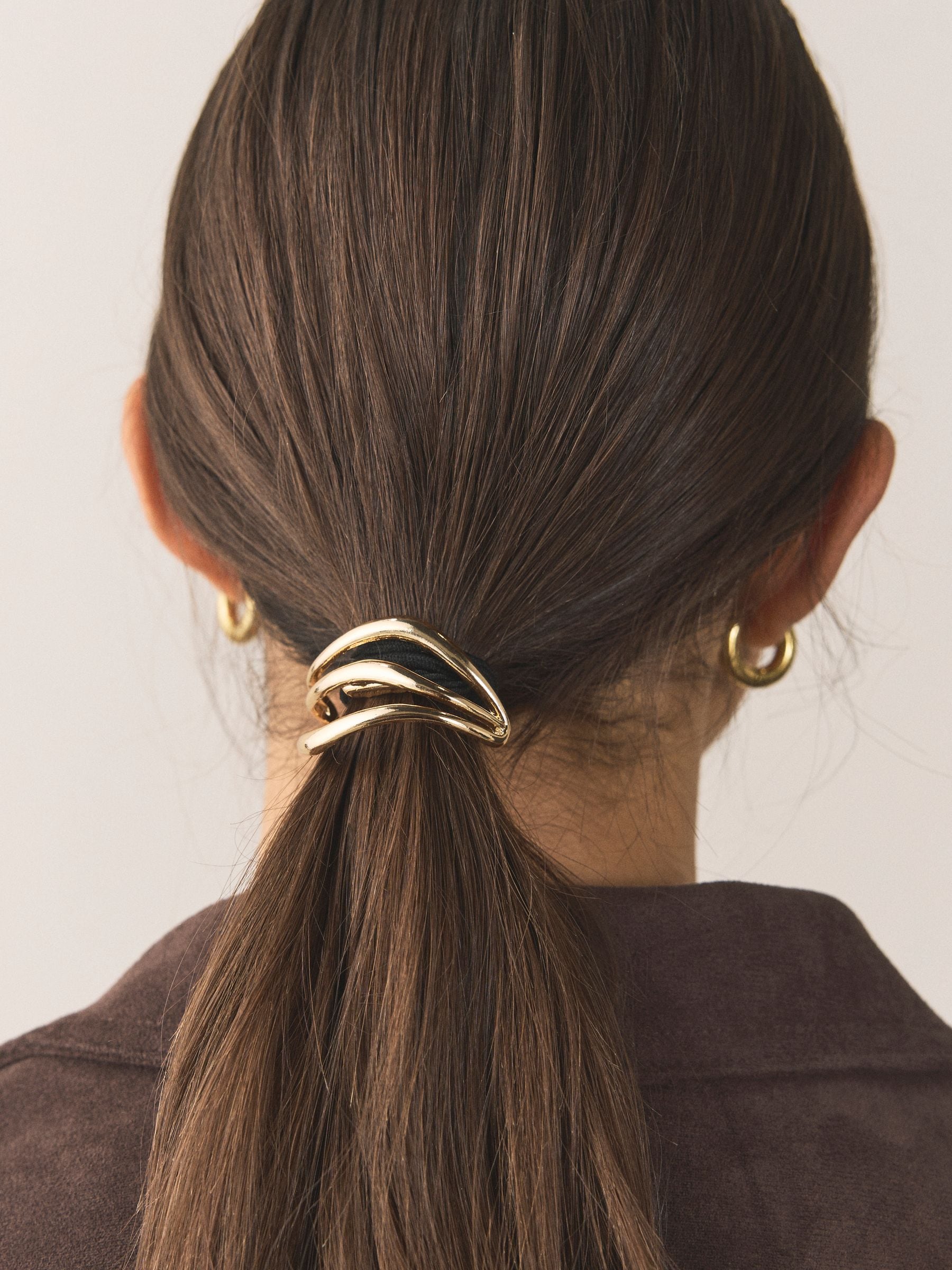 Gold tone metal hair bobble with sculptural design, UK version