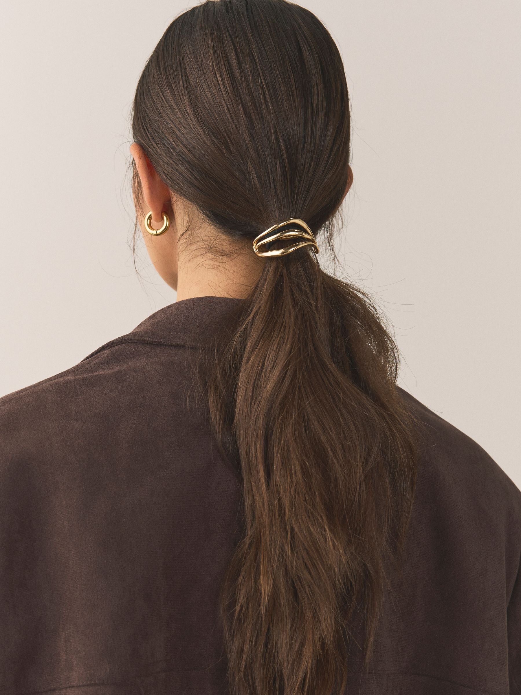 Gold tone metal hair bobble with sculptural design, UK version