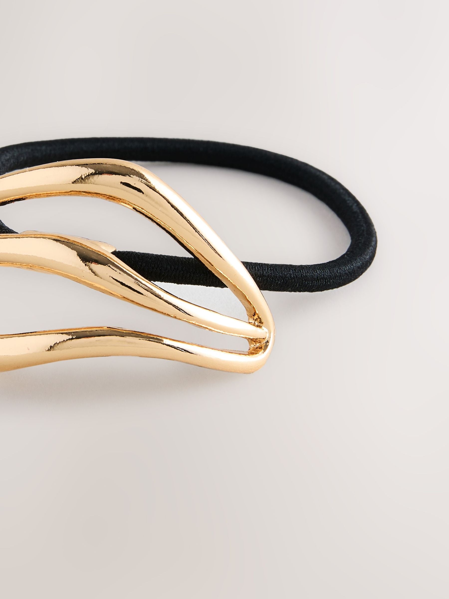 Gold tone metal hair bobble with sculptural design, UK version