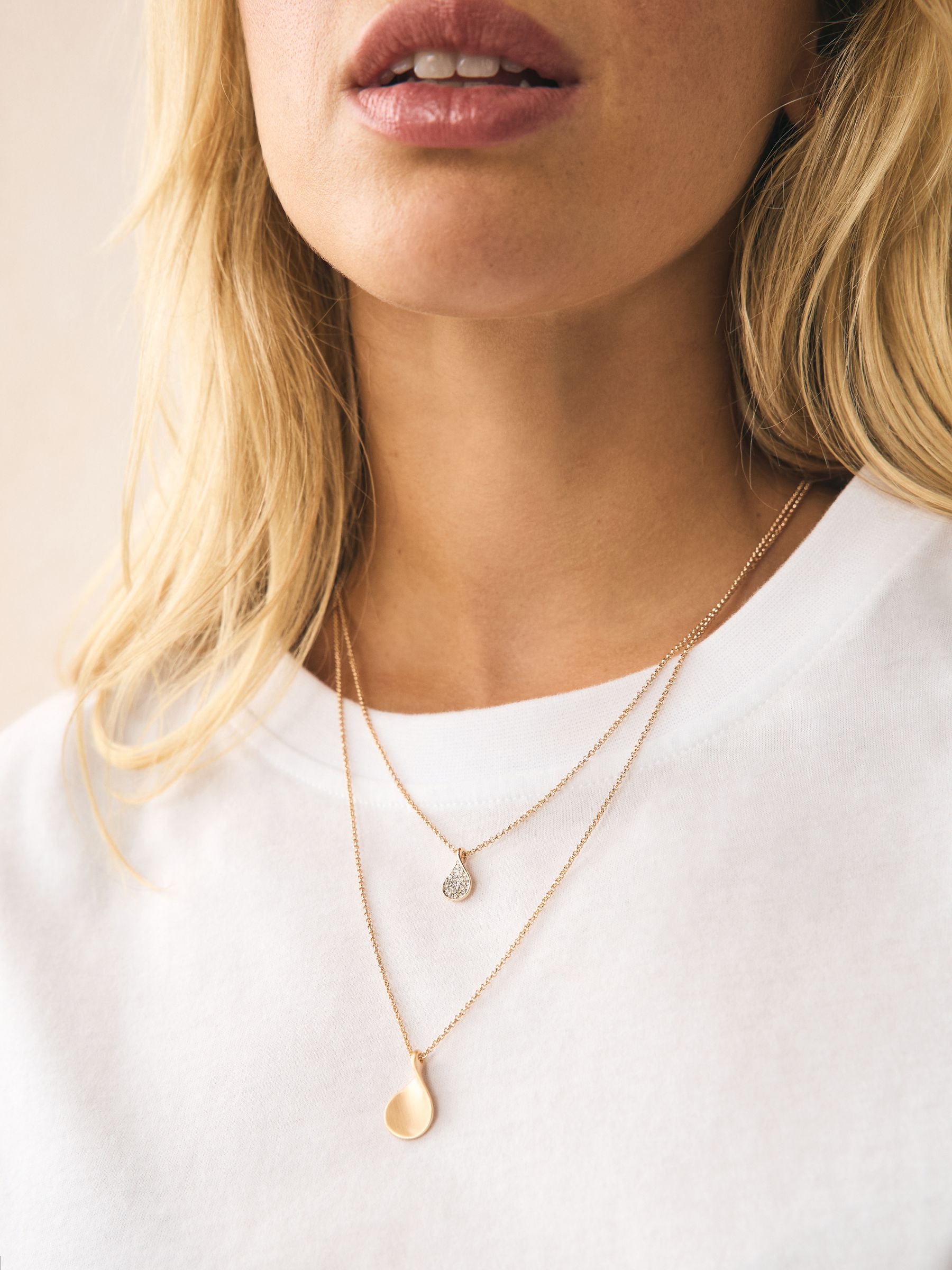 Gold tone layered necklace with sparkling and plain pendants, imported from the UK