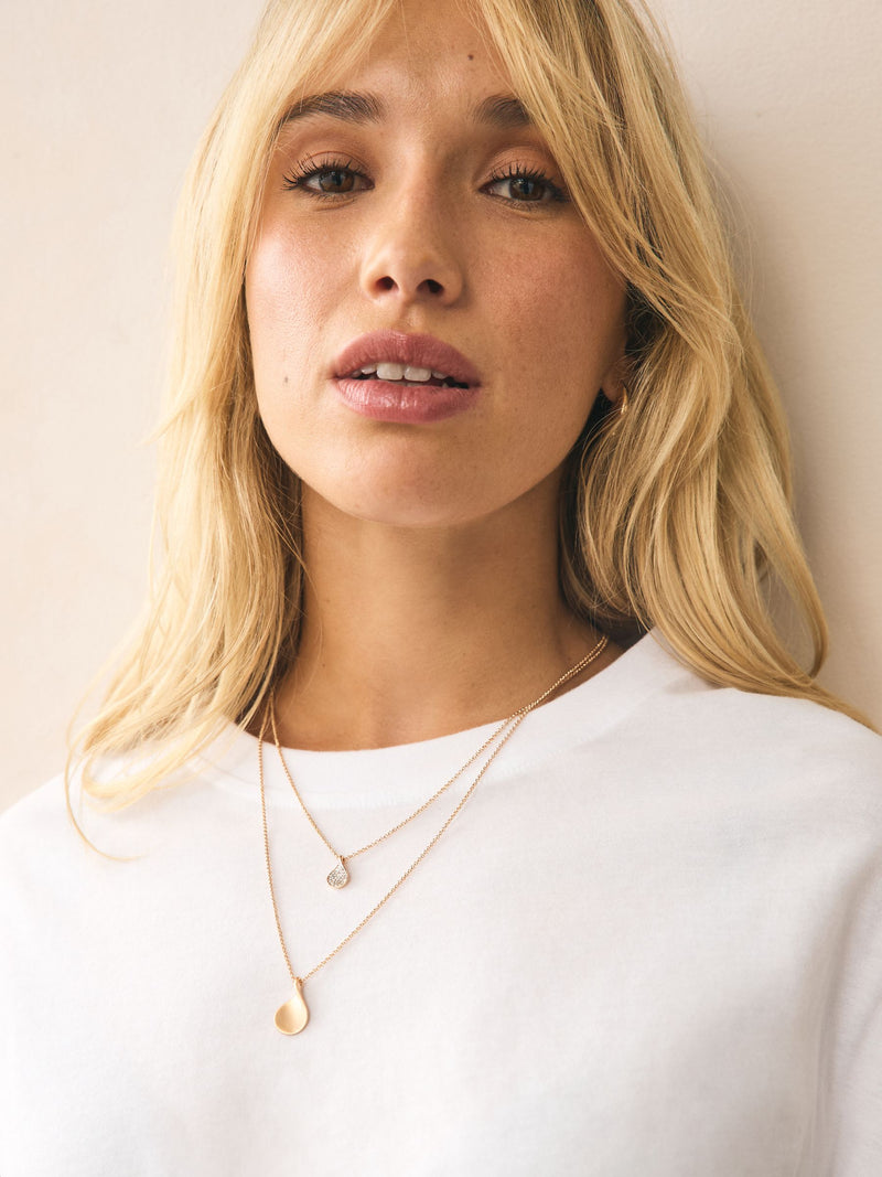 Gold tone layered necklace with sparkling and plain pendants, imported from the UK