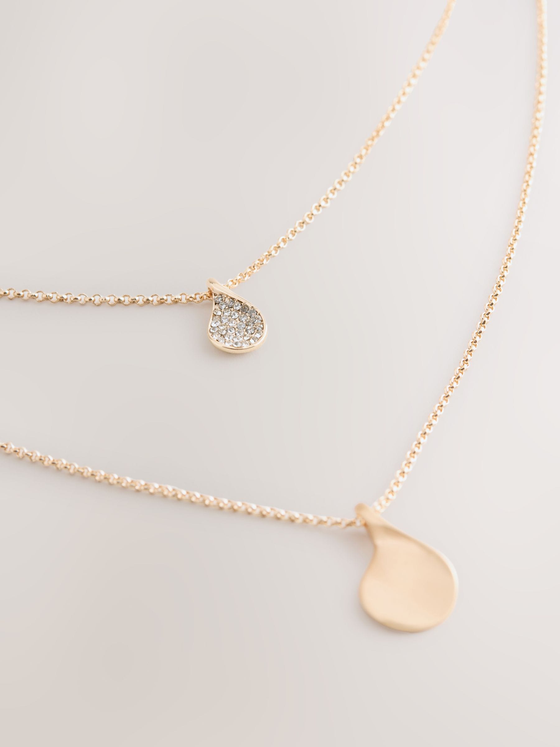 Gold tone layered necklace with sparkling and plain pendants, imported from the UK