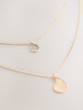 Gold tone layered necklace with sparkling and plain pendants, imported from the UK