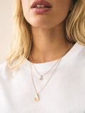 Gold tone layered necklace with sparkling and plain pendants, imported from the UK