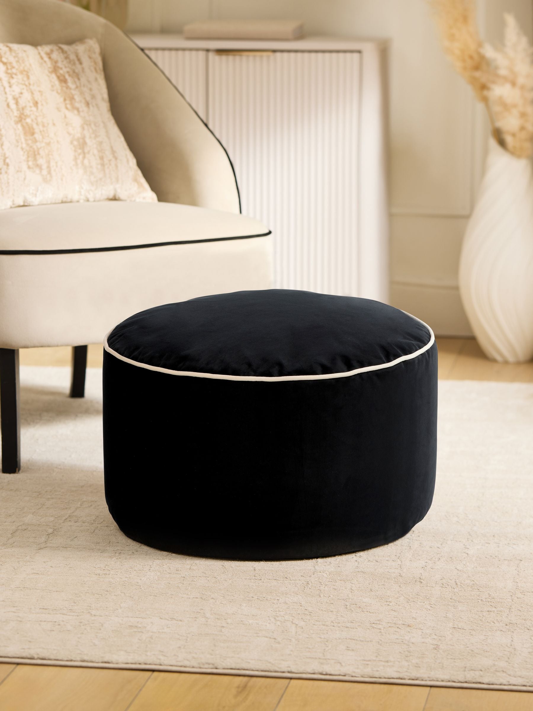 Black velvet pouffe with contrast piping, British brand