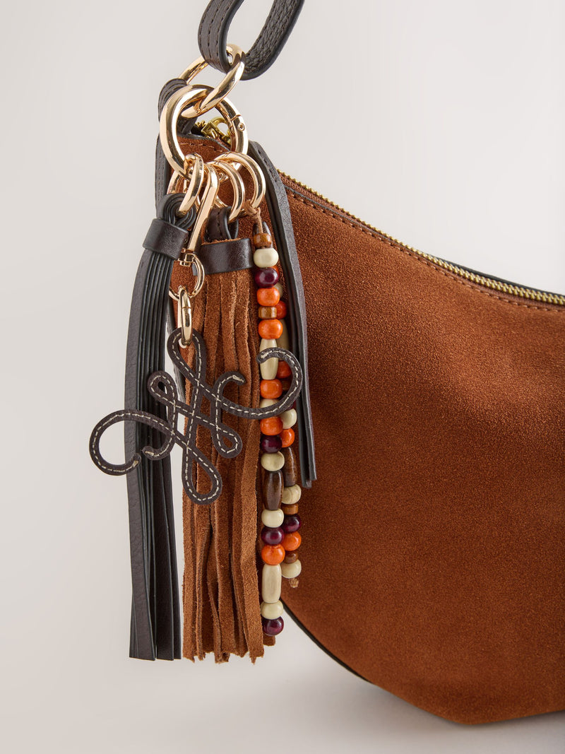 Tan brown suede charm sling bag with tassel, imported from the UK